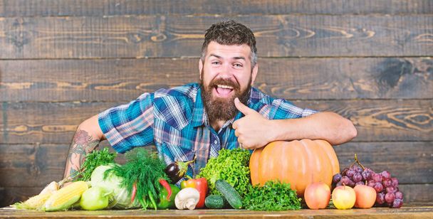 Welcome to my farm. Farmer with homegrown vegetables. Vegetables organic harvest. Farmer rustic style guy. Natural foods. Vegetarian lifestyle concept. Man bearded farmer harvest wooden background - Φωτογραφία, εικόνα