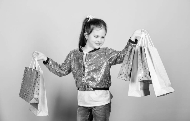 retail. Holiday purchase saving. Cheerful child. Little girl with gift. Sales discounts. Fashion and style. customer with pack. Small girl with shopping bags. Definite must. must have. it is a must - Foto, immagini