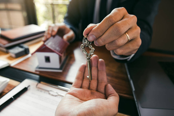 Sprzedawcy domów maklerskich stanowią klucz do nowych właścicieli domów w biurze. - Zdjęcie, obraz