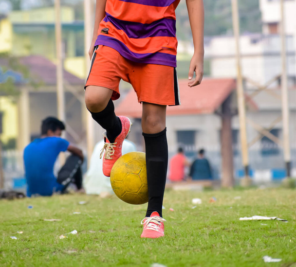 Spor formalı bir futbolcu spor sahasında bir futbol topuyla jonglörlük yapıyor. Yaz kış olimpiyatları spor aktiviteleri arka plan fotoğrafçılığı. - Fotoğraf, Görsel