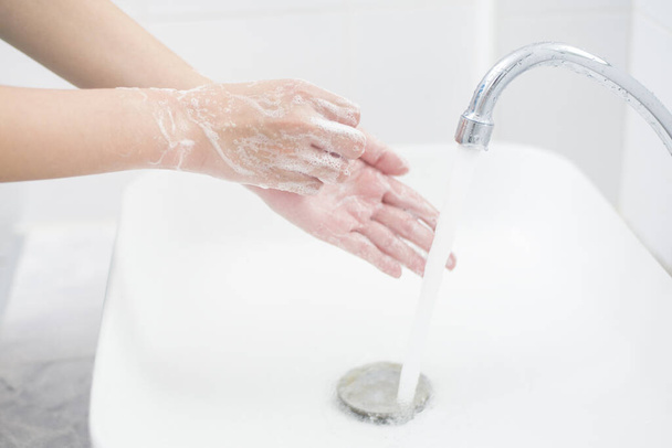 Eine Frau wäscht sich die Hände  - Foto, Bild