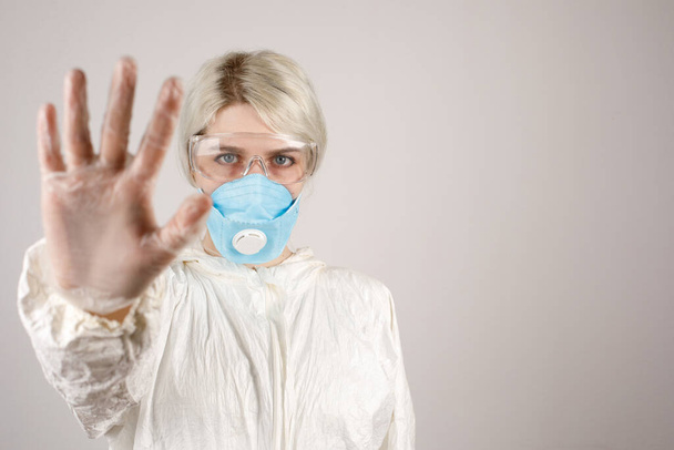 The girl uses a protective suit and a respirator to protect her health from viral, epidemic and infectious diseases. New Covid-19. Corona virus pandemic concept. Stop the virus. - Fotoğraf, Görsel