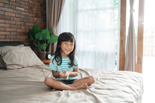 asian young girl kid sitting on the bed - Foto, Imagem
