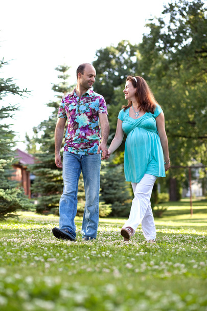 Happy couple, having joined hands walk in park - Фото, изображение