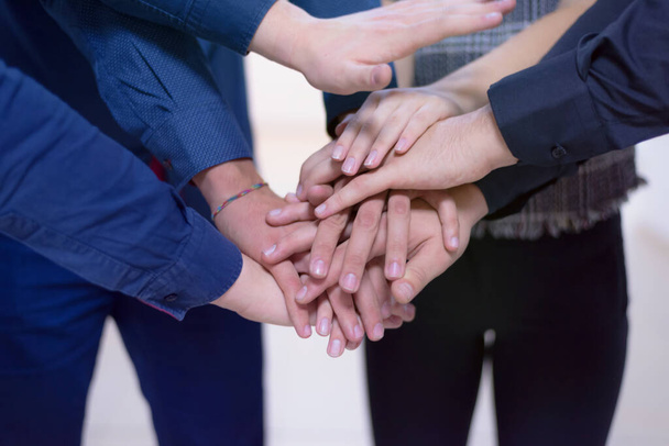 Young business people Teamwork Stacking Hand Concept. Close up of young  business people putting their hands together. Friendly business people  with stack of hands showing unity and teamwork. - Photo, Image