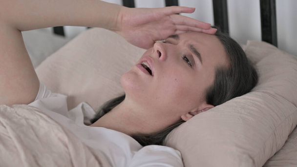 У молодої жінки головний біль у ліжку - Фото, зображення