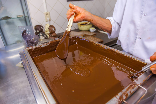 BRUSSELS, BELGIUM - JANUARY 1, 2020: шоколадний кондиціонер робить шоколадну презентацію з какао-бобами, какао-подами і шоколадними формами в шоколадному музеї в Брюсселі, Бельгія. - Фото, зображення