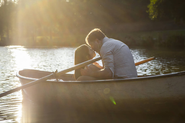 Ρομαντικό ζευγάρι σε μια βάρκα στο ταξίδι του μέλιτος απολαμβάνοντας τις καλοκαιρινές διακοπές.  - Φωτογραφία, εικόνα