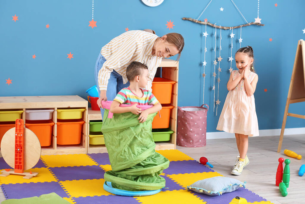 Kindermädchen und süße kleine Kinder spielen zu Hause - Foto, Bild