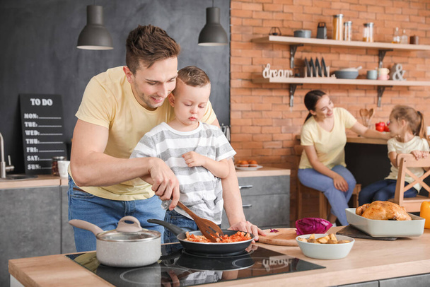 Отец с сыном готовят вместе на кухне
 - Фото, изображение
