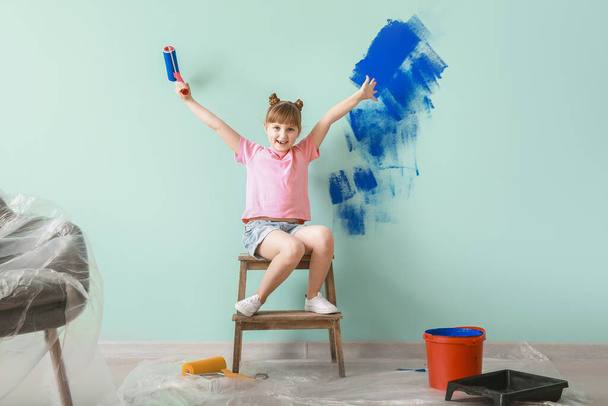 Little girl painting wall in room - Φωτογραφία, εικόνα