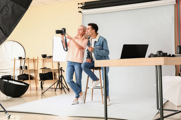 Profi-Fotograf zeigt Bilder zum Modeln im Studio - Foto, Bild