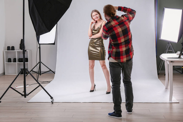 Fotógrafo profesional trabajando con modelo en estudio
 - Foto, imagen