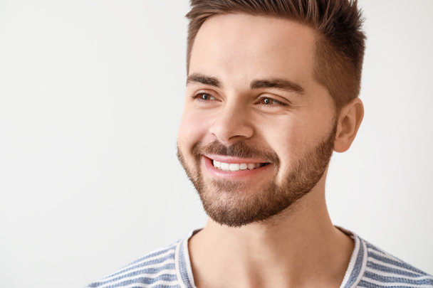 Szép, mosolygós fiatalember fehér háttér - Fotó, kép