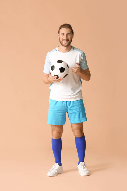 Male football player on color background - Foto, afbeelding