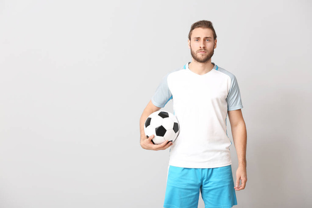 Male football player on grey background - Foto, imagen