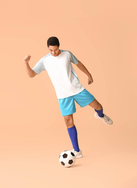 Joven jugador de fútbol afroamericano sobre fondo de color
 - Foto, imagen