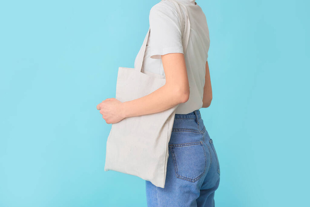 Vrouw met eco tas op kleur achtergrond - Foto, afbeelding