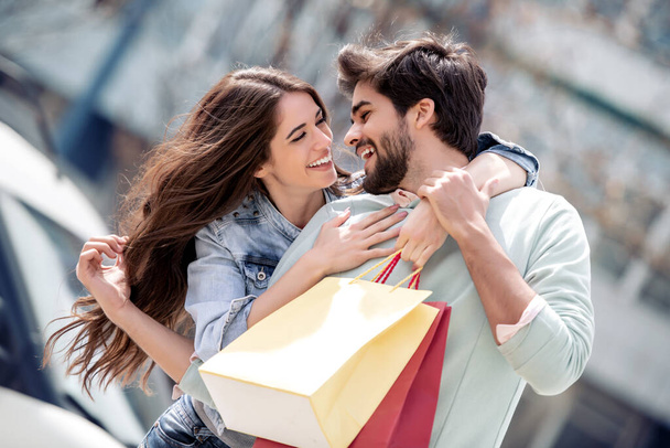 Şehirde alışveriş torbaları olan bir çiftin portresi. İnsanlar, satış, aşk ve mutluluk konsepti.. - Fotoğraf, Görsel