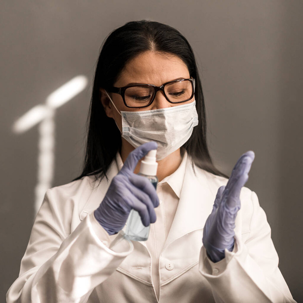 Asian doctor protective mask with antiseptic spray. Infectious dangerous. Glove protection. Working hospital. Medicine concept. Virus. Test. Copy space - 写真・画像