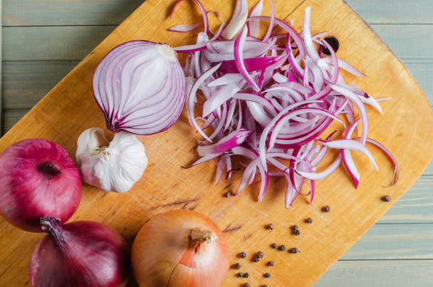 Red onion sliced. The process of cooking on a yellow cutting Board. Flat top view. - Foto, Imagen