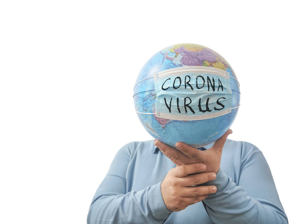 World Epidemic Danger. World need protect the earth globe with a face mask and hands, isolated on a white background. Human Epidemic Danger. globe map with virus mask behind male face.  - Foto, imagen