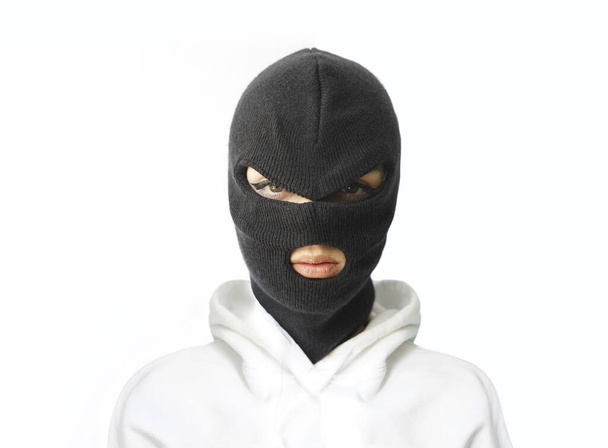 woman wearing white hoodie, balaclava or black mask  isolated on white   wall  background .  - Foto, afbeelding