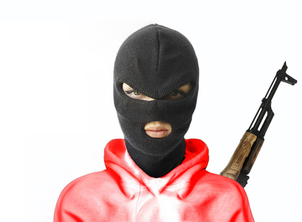 woman wearing red  hoodie, balaclava or black mask  isolated on white  background . machine gun hangs behind back.  - Φωτογραφία, εικόνα