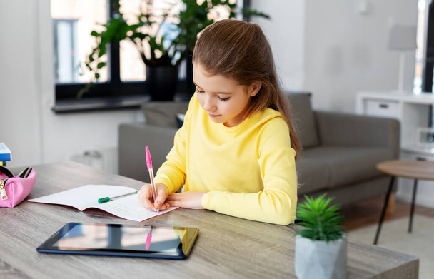 student girl writing to notebook at home - Valokuva, kuva