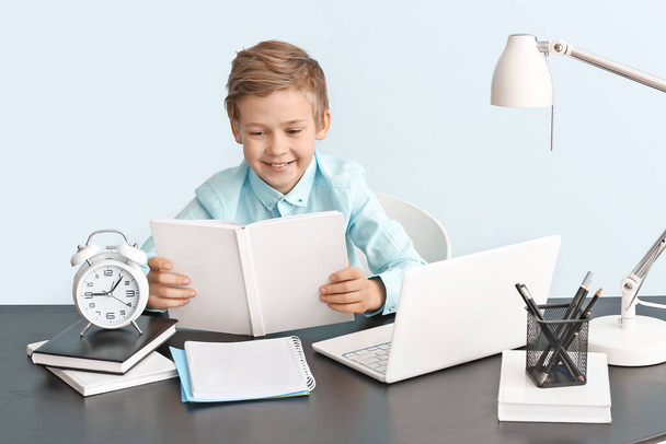 Roztomilý chlapeček dělá domácí úkoly u stolu - Fotografie, Obrázek