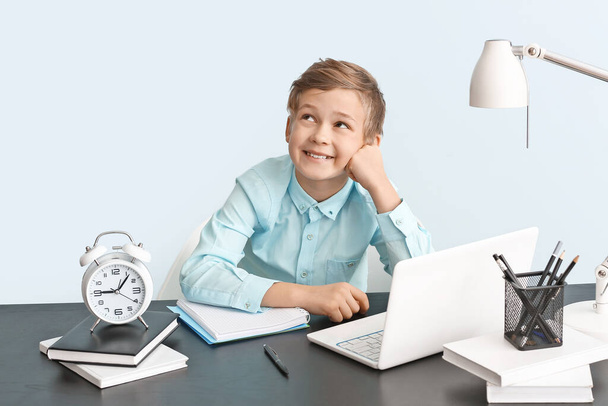Roztomilý chlapeček dělá domácí úkoly u stolu - Fotografie, Obrázek