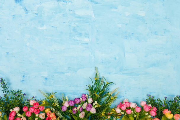 Mesterséges lila, rózsaszín, sárga és fehér virágok kék festett fa háttér. Tavaszi virágzás, Húsvét, nőnap, anyák napja, március 8. Fénymásolási hely. - Fotó, kép