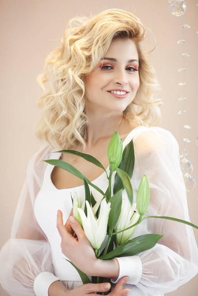 Attractive young woman portrait. Beautiful lady indoors. Female holding flowers. - Foto, afbeelding