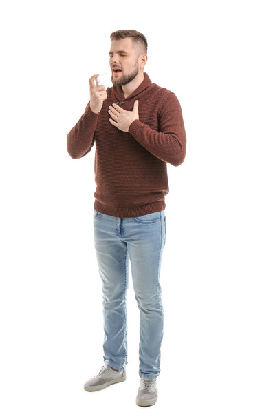 Ill young man with inhaler on white background - Fotografie, Obrázek