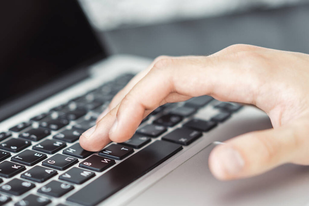 Hombre manos escribiendo en el teclado del ordenador portátil en la oficina soleada, negocio y concepto de tecnología. De cerca.
 - Foto, imagen