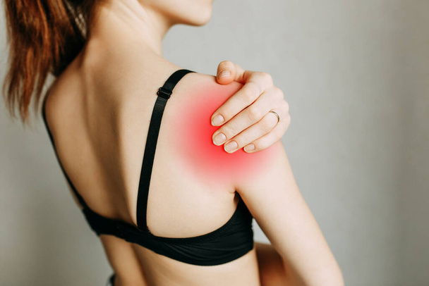 Shoulder and joint injuries, and fatigue at work. The zone of injury, the image on a blank background. A spasm on the girl's shoulder.  - Foto, Imagen