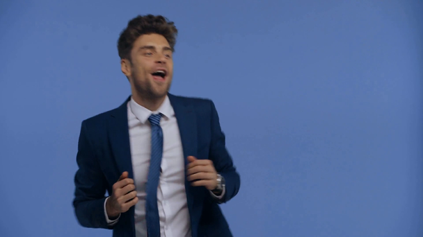 Θετικός επιχειρηματίας που χορεύει και τραγουδάει απομονωμένος στο μπλε - Πλάνα, βίντεο
