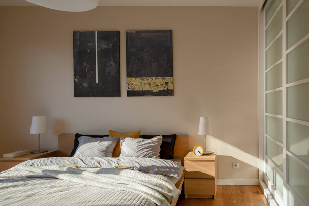 Stylish bedroom with big double bed in morning sunlight - Valokuva, kuva