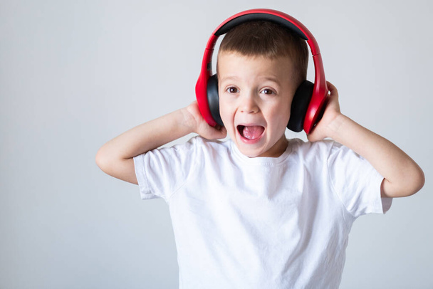 Διασκεδαστικό μικρό παιδί που απολαμβάνει ρυθμούς ακούγοντας μουσική στα ακουστικά - Φωτογραφία, εικόνα