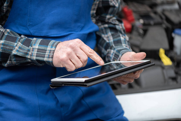 Car mechanic using digital tablet for checking car engine - Photo, Image