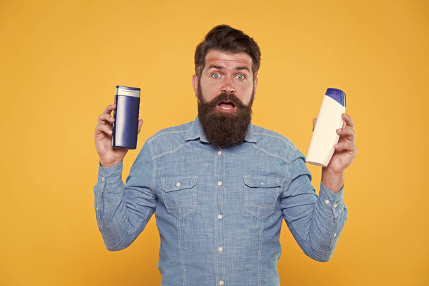 Perfect for modern man on go. Bearded man hold hair and body wash. Brutal man in casual style. Caucasian man with cosmetic products. Cosmetics and toiletries. Hygiene and health. For daily routine - Photo, Image