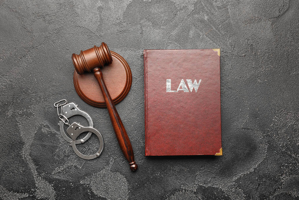 Judge's gavel, book and handcuffs on grey background - Foto, imagen