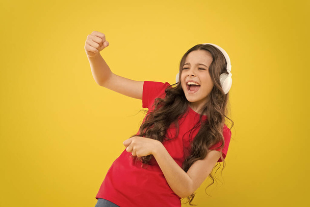 Top songs. Child teen enjoy music playing in earphones. Little girl enjoying favorite music. Catch the rhythm. Kid listening music headphones. Entertainment and fun. Whole musical world in her ears - 写真・画像