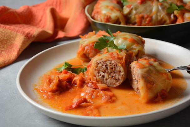 Cabbage rolls stuffed with ground beef and rice in tomato sauce - Фото, изображение