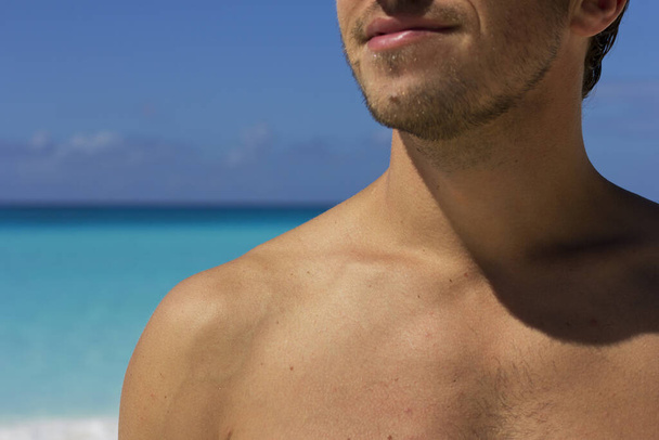 Молодой человек загорает на пляже. Загар на белой коже. Кожа под влиянием солнца
. - Фото, изображение