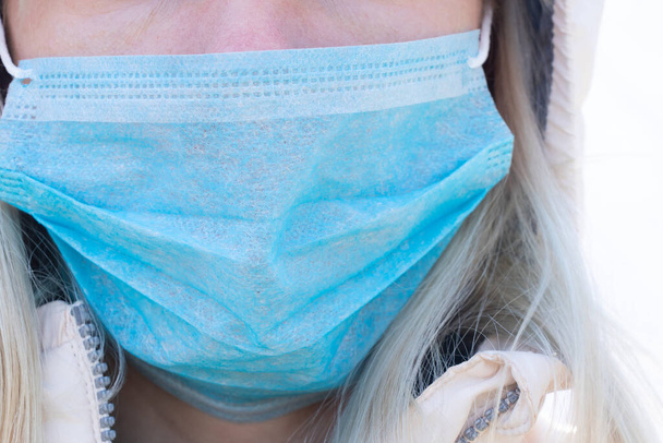 primer plano de una joven ucraniana con una máscara médica en la cara durante la pandemia al aire libre
 - Foto, imagen