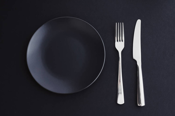 黒の背景に空のプレートと銀食器、休日の夕食のためのプレミアム食器、ミニマルなデザインと食事 - 写真・画像