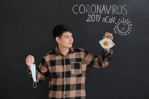 Siyah arka planda maskeli bir Asyalı. Koronavirüs salgını kavramı - Fotoğraf, Görsel