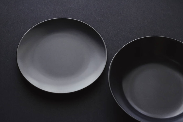 Pratos vazios em fundo preto, louça premium para jantar de férias, design minimalista e dieta
 - Foto, Imagem
