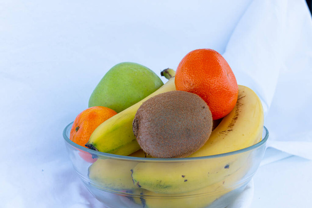 μπολ με διαφορετικά φρούτα σε λευκό φόντο - Φωτογραφία, εικόνα